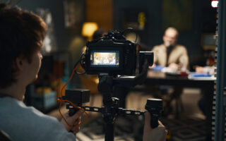 Operator using professional camera to shoot video of podcast in studio